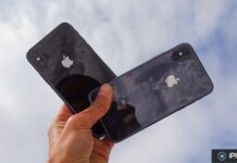 Deux iPhone noirs tenus en main sous le ciel