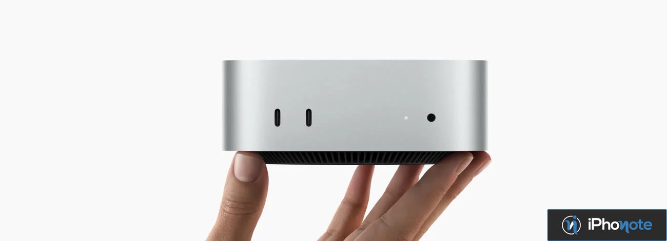 Mac mini compact tenu entre les doigts