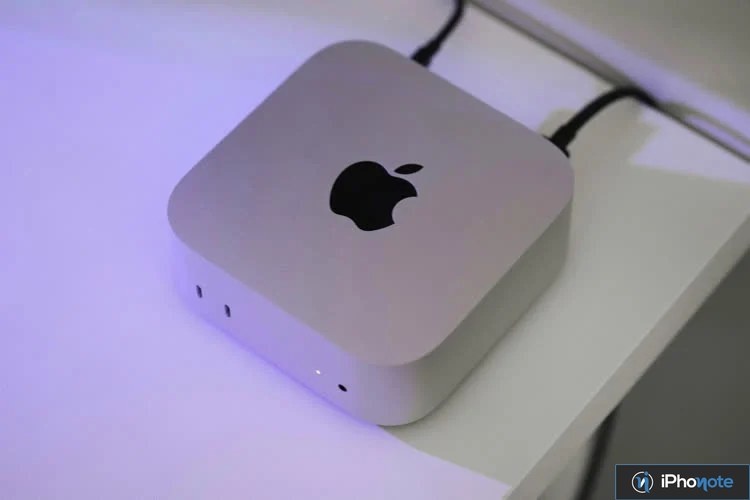 Mac mini Apple posé sur un bureau avec éclairage violet