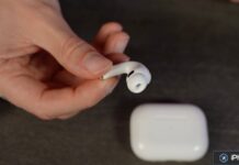 Main tenant une oreillette AirPods avec son boîtier
