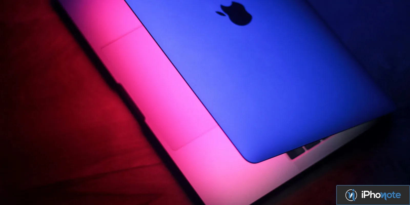 Ordinateur portable Apple éclairé par des lumières bleue et rose