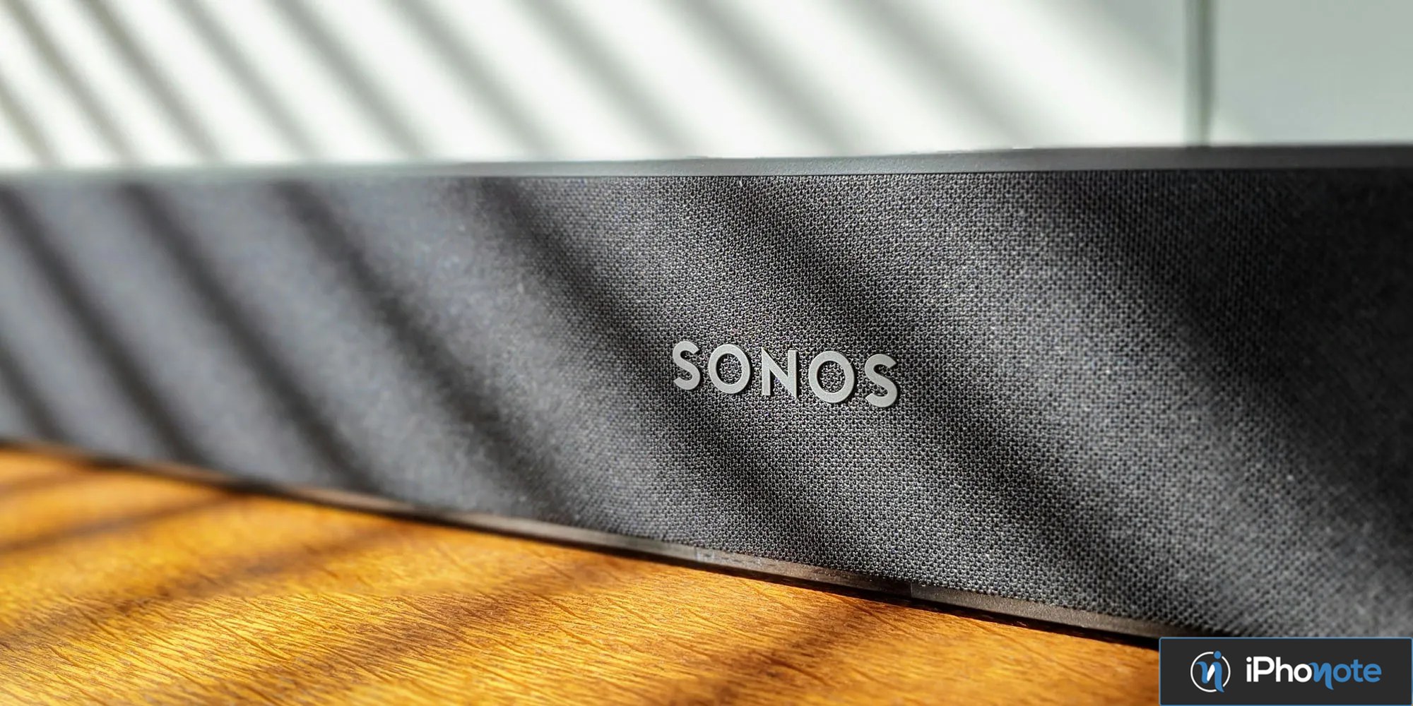 Enceinte connectée Sonos noire posée sur une table en bois