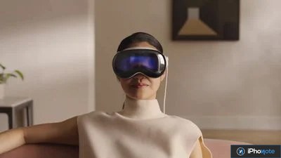 Une personne assise porte un casque Apple Vision Pro