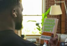 Homme portant des AirPods et lisant le titre d’un livre