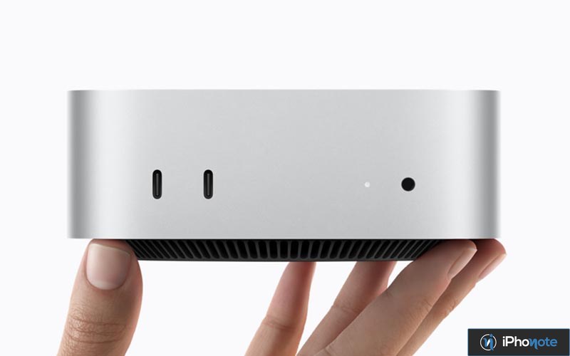 Mac mini argenté tenu entre les mains, avec ports visibles