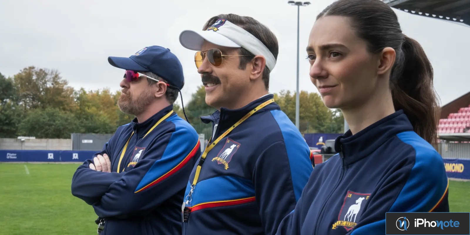 Trois membres de l’équipe de Ted Lasso sur un terrain de football