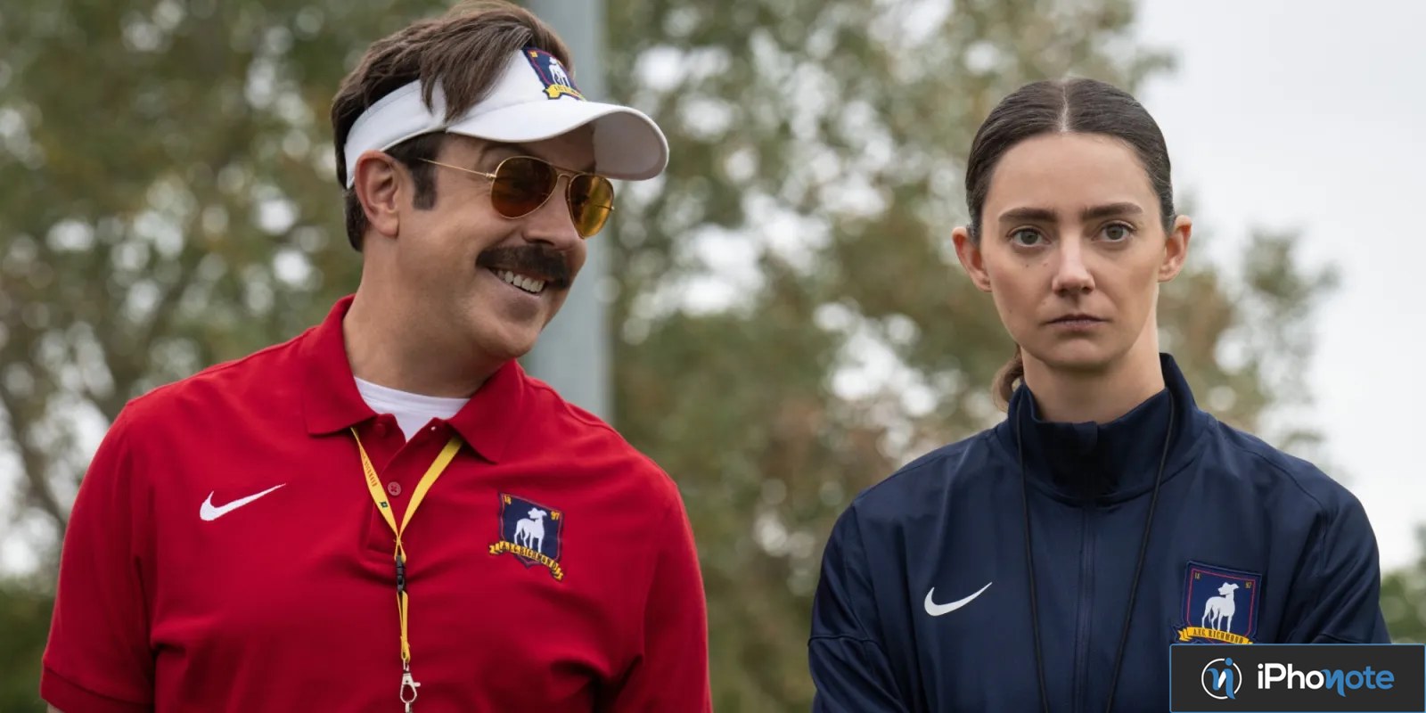 Ted Lasso et une entraîneuse posent côte à côte